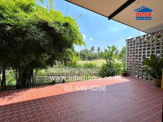 Spacious patio with a view of a pond and lush greenery