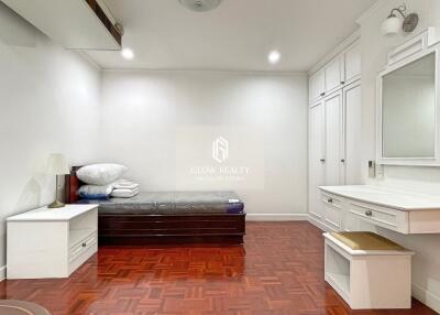 Spacious bedroom with white furniture and wooden floor