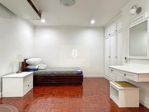 Spacious bedroom with white furniture and wooden floor