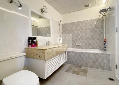 Modern bathroom with a vanity, bathtub, and toilet