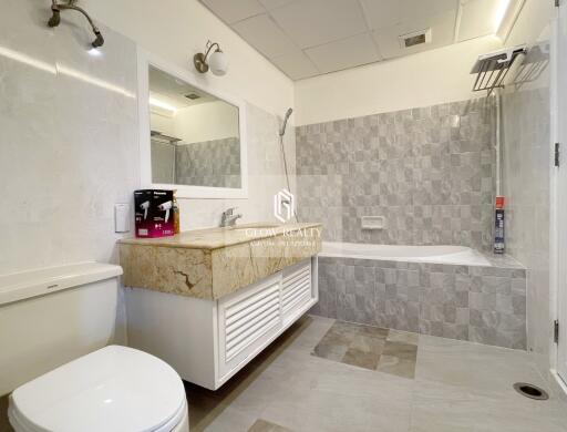 Modern bathroom with a vanity, bathtub, and toilet