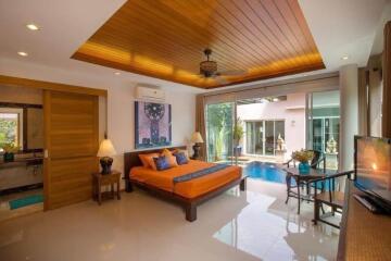 Spacious bedroom with pool view, large bed, and modern furnishing