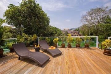 Spacious terrace with lounge chairs and a view of surrounding greenery