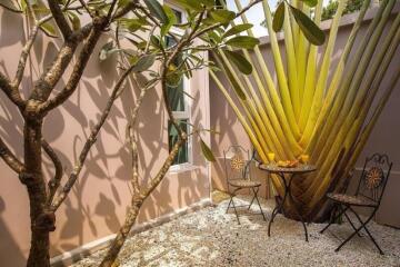 Cozy outdoor seating area with a small table and chairs surrounded by plants