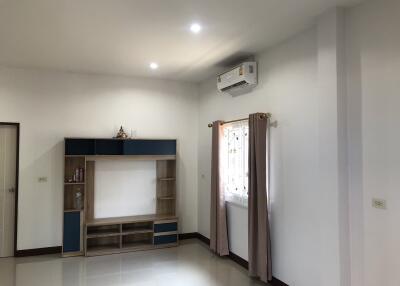 Modern living room with light-colored walls, a storage unit, and an air conditioner