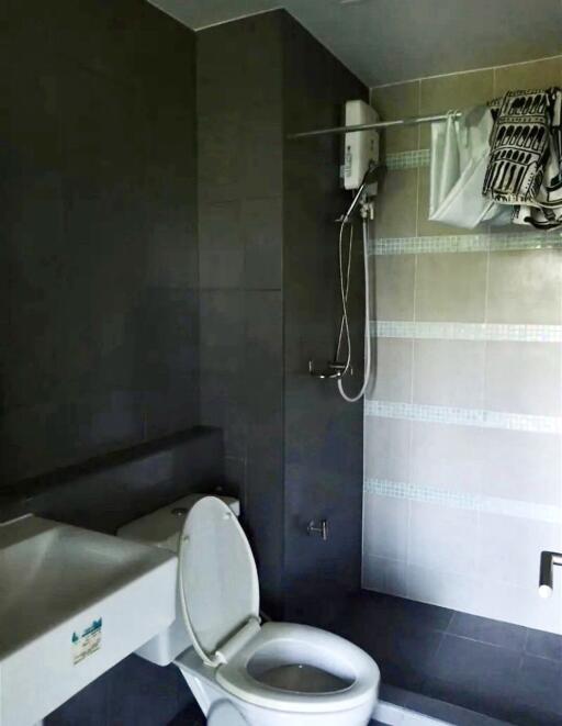 Modern bathroom with toilet, sink, and shower.