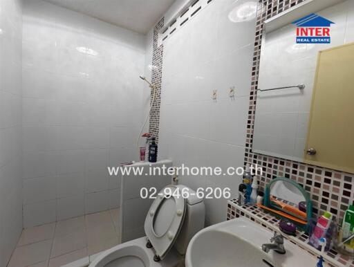 Bathroom with toilet, shower, sink and mirrors