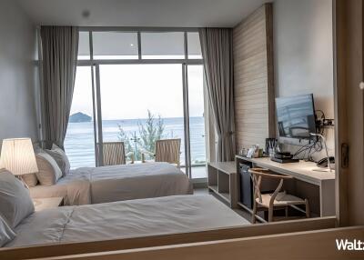 Bedroom with twin beds, sea view, and desk area