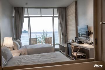 Bedroom with twin beds, sea view, and desk area