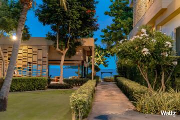 Pathway leading to modern outdoor seating area with greenery and ocean view