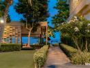 Pathway leading to modern outdoor seating area with greenery and ocean view