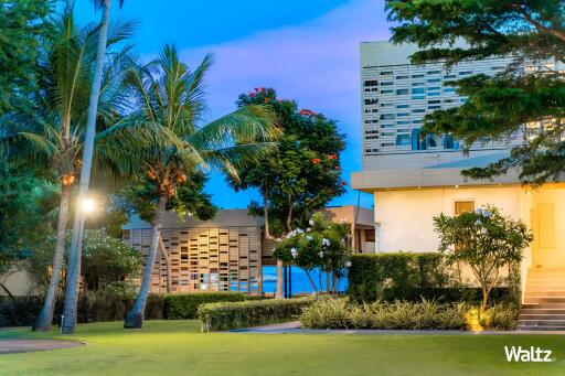 Exterior of a modern building with a well-maintained lawn and palm trees