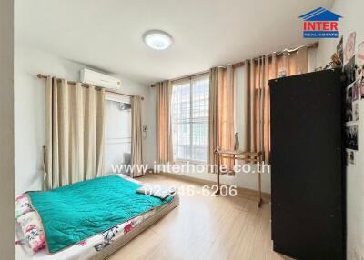 Well-lit bedroom with bed, curtains, and a window