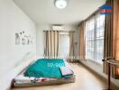 Simple bedroom with a mattress on the floor and large window with curtains