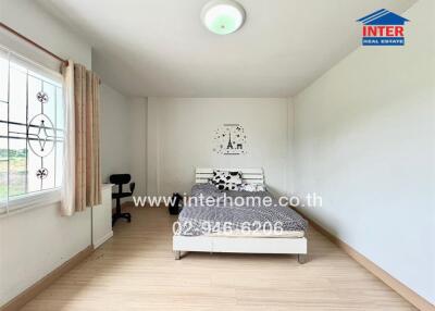 Spacious bedroom with large window and wooden floor