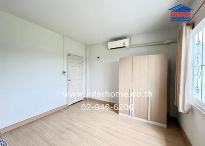 Bedroom with wooden wardrobe and air conditioning unit