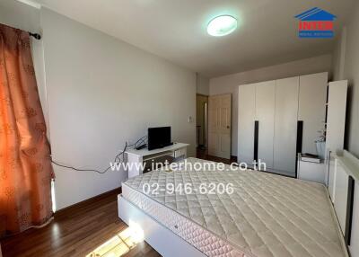 Bedroom with illuminated ceiling light, bed frame, and wardrobe