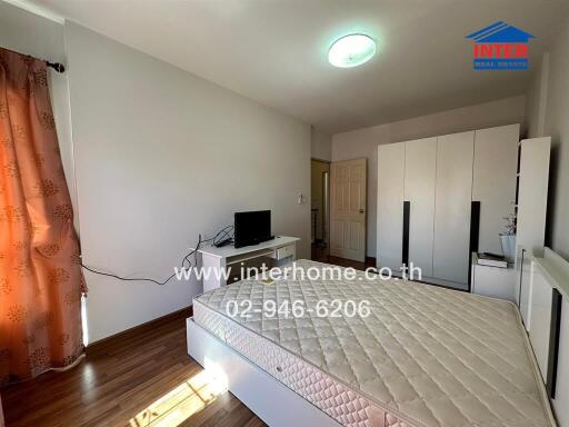 Bedroom with illuminated ceiling light, bed frame, and wardrobe