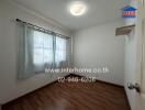 simple bedroom with wooden floor and a window with curtains