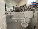 Modern bathroom with black and white tile accent wall, sink, toilet, and shower