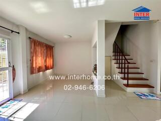 Bright living room with stairs and large window