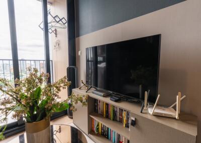 Living room with TV, bookshelf, and balcony