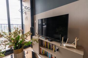 Living room with TV, bookshelf, and balcony