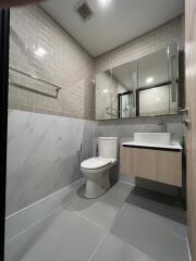 Modern bathroom with subway tile walls, floating vanity, and large mirror