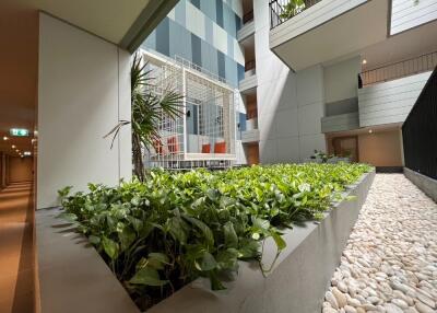 Modern apartment building atrium with plants and seating area