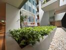 Modern apartment building atrium with plants and seating area