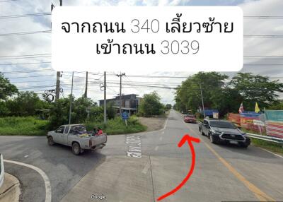 Street view of a junction with vehicles and directions shown in Thai language