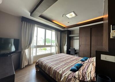 Spacious bedroom with large window and modern furnishings
