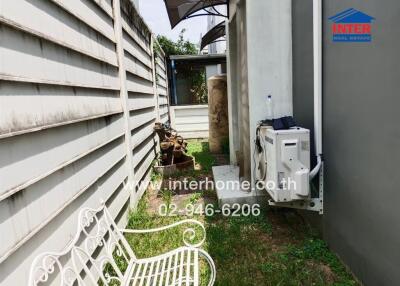 Outdoor space with concrete wall, air conditioning unit, and garden bench