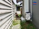 Outdoor space with concrete wall, air conditioning unit, and garden bench