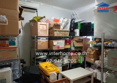 Photo of a cluttered storage room with shelves filled with boxes and miscellaneous items