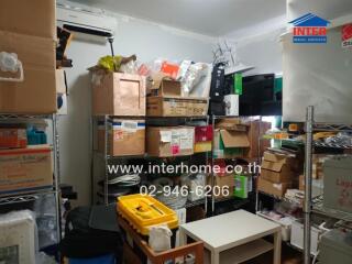 Photo of a cluttered storage room with shelves filled with boxes and miscellaneous items