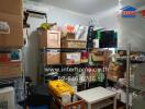 Photo of a cluttered storage room with shelves filled with boxes and miscellaneous items