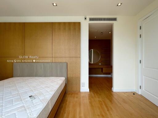 Spacious bedroom with wooden flooring and built-in closet