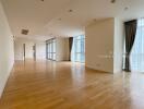 Spacious living area with wooden flooring and large windows