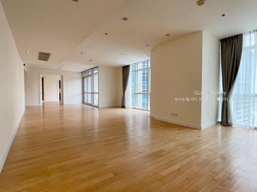 Spacious living area with wooden flooring and large windows