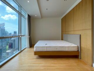 Spacious bedroom with large windows and city view