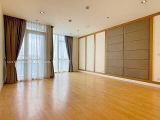 Spacious living room with large windows and wooden flooring