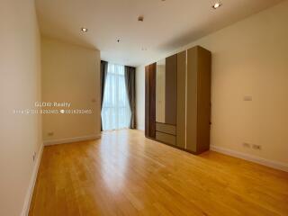 Spacious bedroom with wooden flooring and a large wardrobe