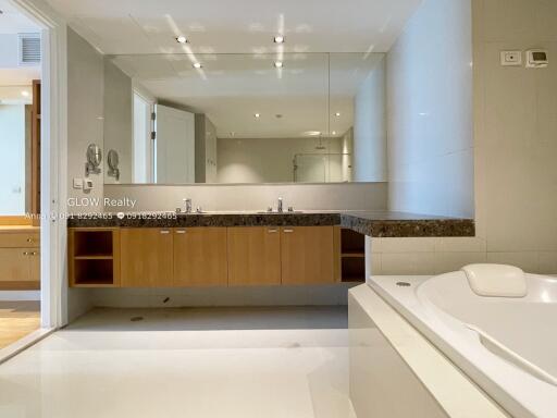 Spacious modern bathroom with large mirror and bathtub