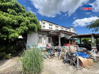 Exterior of a residential property with plants and miscellaneous items