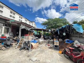 Photo of an outdoor area with various items and a building in the background