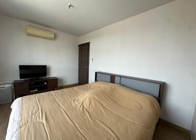 Bedroom with bed, television, air conditioner, and wooden furniture