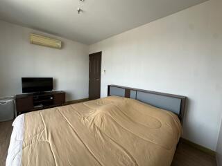 Bedroom with bed, television, air conditioner, and wooden furniture