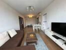 Living room with sofa, coffee table, TV and dining area