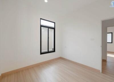 Bedroom with wooden floor and large window